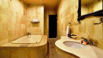 Un baño con bañera, lavabo y espejo.