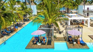 A poolside area with lounge chairs, umbrellas, and a wooden deck.