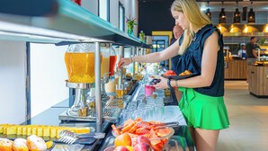 A buffet setup with a variety of fruits and a beverage dispenser.