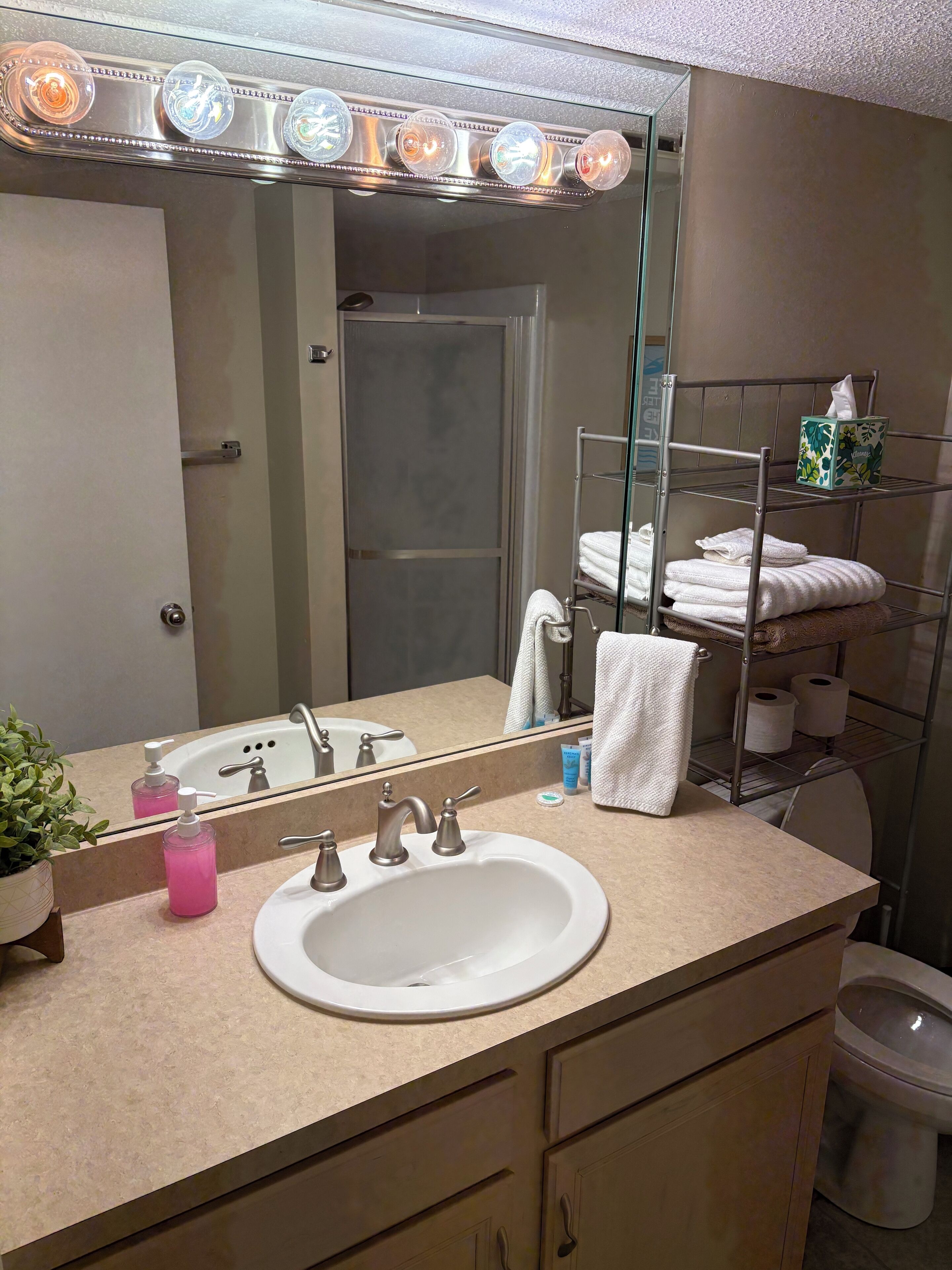 A bathroom with a sink, mirror, and towel rack.