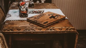 Een tafel met een biertje, een kaartspel en een decoratie.