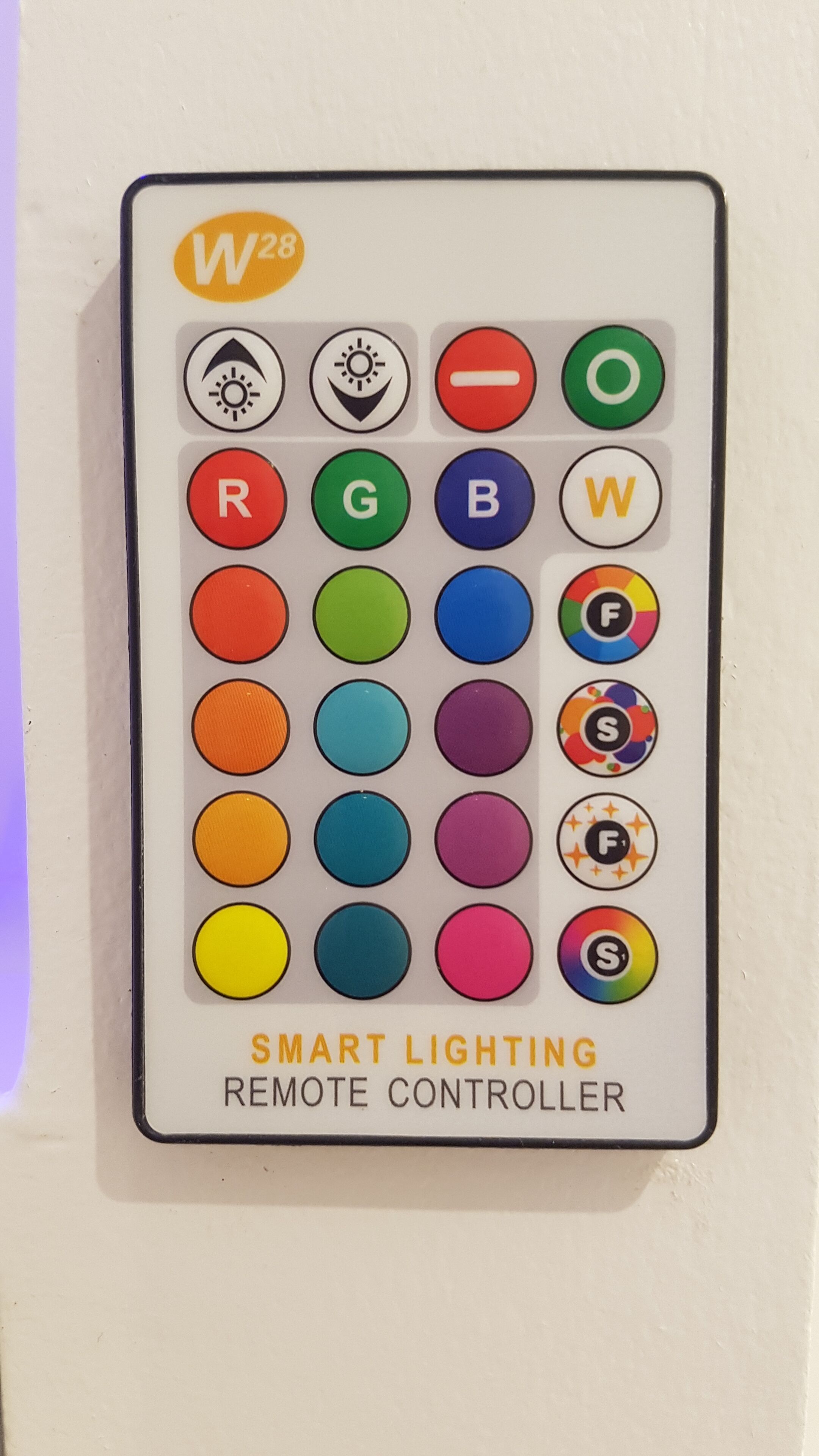 A smart lighting remote controller with various color buttons and symbols.