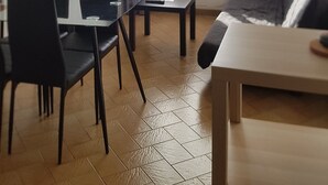 Un soggiorno con zona pranzo, un divano, un tavolo e un quadro appeso al muro.