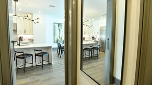 Une cuisine moderne dotée d’un îlot central, de tabourets de bar et de luminaires au design contemporain.