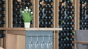A wine rack with bottles and a potted plant on a counter. - Weingut Bugner Meizelhof (Klein-Winternheim)