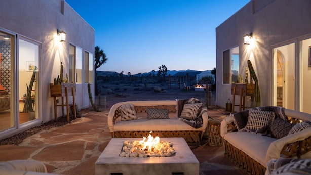Una terrazza esterna con un braciere, una zona salotto e ampie finestre.