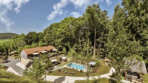A resort with a swimming pool, outdoor seating, and a large building with a red roof. - L'Atelier d'Epicure - Logis (Castels et Bézenac)