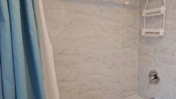 Ein Badezimmer mit einer Badewanne, einer Dusche und einem Handtuchhalter.