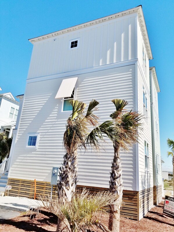 Un bâtiment blanc à deux étages, doté d’une petite fenêtre et d’une porte.