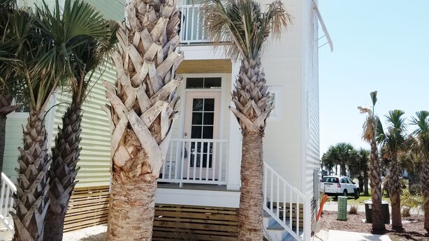 A two-story building with a balcony and palm trees in front. - Ocean Views!102 West Terminal Blvd Unit #15 Atlantic Beach, NC (Atlantic Beach)