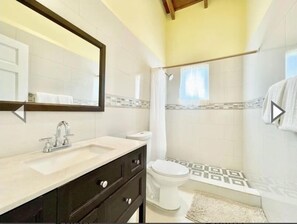 Tina con regadera, tina de hidromasaje, secadora de cabello, toallas