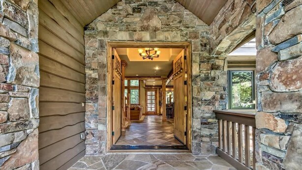 A stone-walled hallway with a wooden door and a chandelier. - Hot Tub, Game Room, Near Lake, Walk to Trails (South Lake Tahoe)