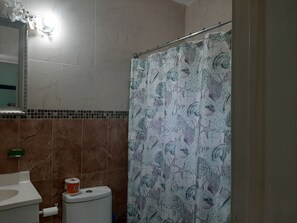 Een bad/douchecombinatie, handdoeken