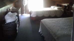 A small, dimly lit attic room with two beds, a desk, and a window. - Lake front Rental!!!  (eagle lake)