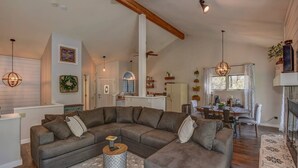A spacious living room with a large sectional sofa, a dining area with a table and chairs, and a kitchen in the background. - Close to Prescott Square,2 Pools,Playground,Tennis,Pickle Ball,Trails,Wildlife (Prescott)