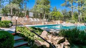 A pool area with lounge chairs and a staircase leading to a pool deck. - Close to Prescott Square,2 Pools,Playground,Tennis,Pickle Ball,Trails,Wildlife (Prescott)