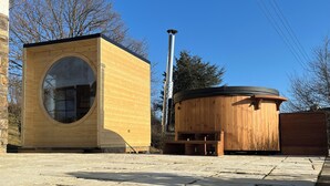 A wooden structure with a circular window and a cylindrical building.