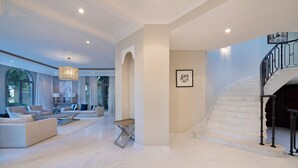 Un vaste espace de vie agrémenté d’un escalier moderne et d’une grande fenêtre.