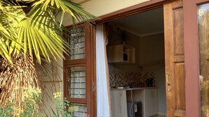A kitchen with wooden cabinets, a microwave, and a coffee maker. - Cozy Guestrooms in Midrand (Midrand)