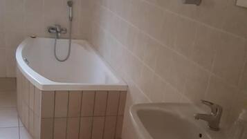 Une salle de bain avec une baignoire, un lavabo et un porte-serviettes.