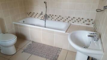 Un baño con bañera, inodoro y lavabo.