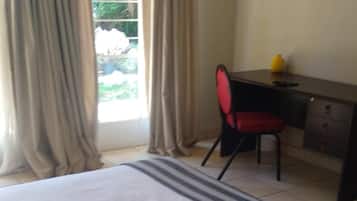 A hotel room with a bed, a desk, and a chair.