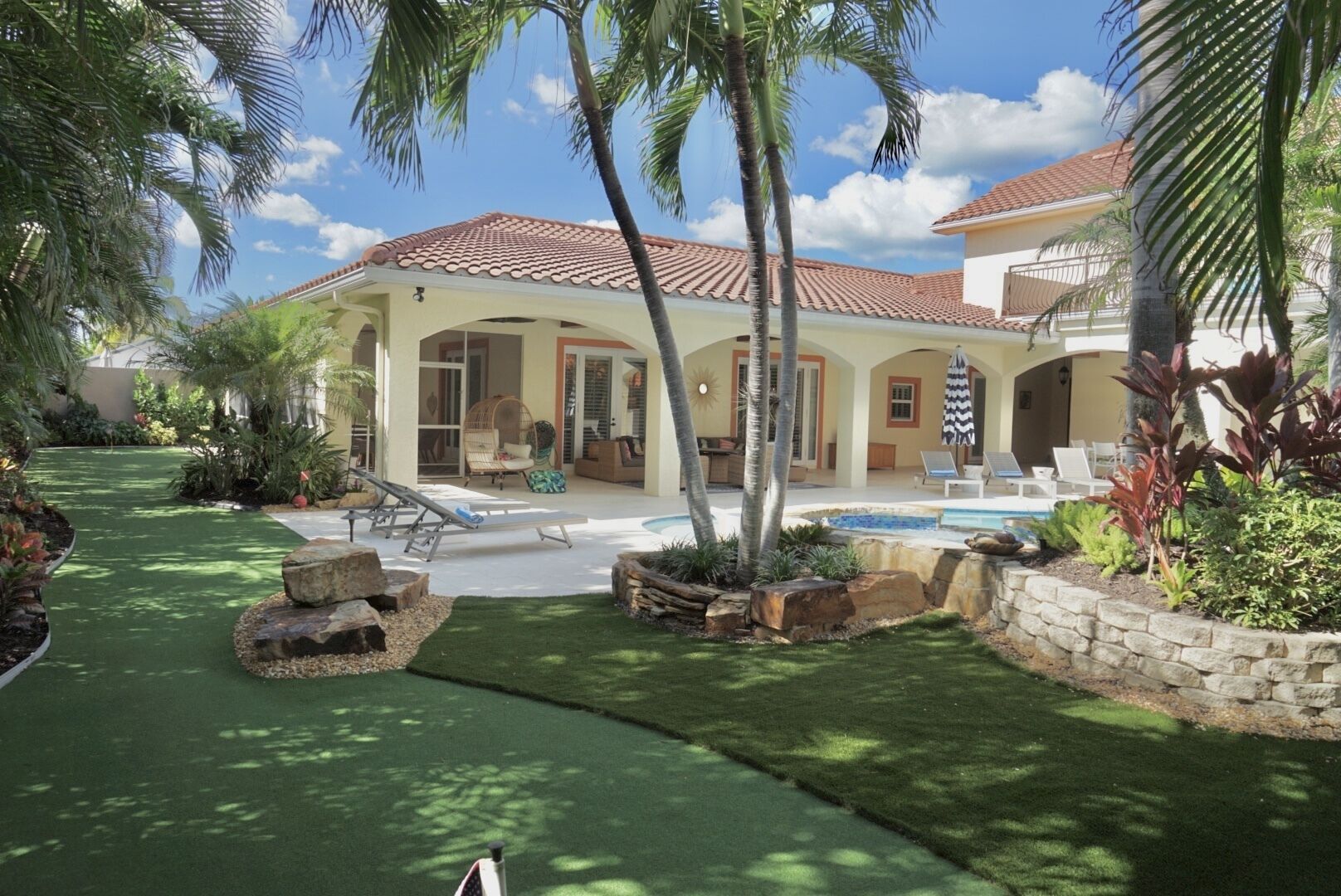 Une maison avec une piscine, un espace salon extérieur et un jardin bien entretenu.