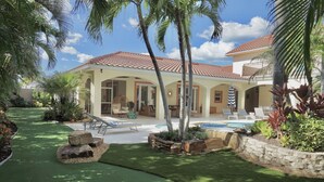 A house with a swimming pool, outdoor seating, and a well-maintained garden. - Paradise Palm Villa- SEE OUR NEW POOL AREA AND OUTDOOR KITCHEN!  (Naples)
