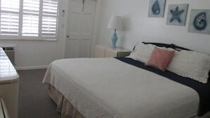 Una camera da letto con un letto, un comodino, una lampada e decorazioni alle pareti.