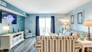 Un salon comprenant un téléviseur, un canapé et un coin repas.