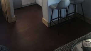 A kitchen with a central island, bar stools, a microwave, a toaster, and a sink. - Beautiful Asheville Tiny Home Get-a-way (Asheville)