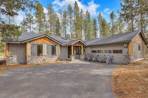 Une maison à deux étages avec des fondations en pierre, un garage et une véranda.