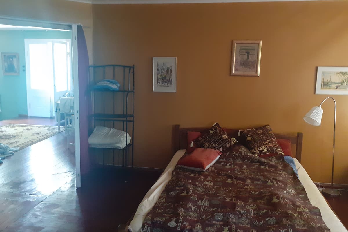 Um quarto com uma cama, uma cama beliche e um abajur.