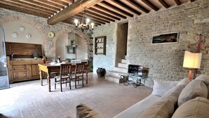 Un intérieur rustique comprenant un coin repas, une cuisine et un espace de vie chaleureux avec un canapé.