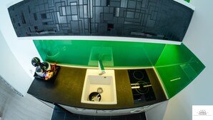 Eine moderne Küche mit gewölbter Rückwand, einem Spülbecken und einer Arbeitsplatte mit grünen Akzenten.