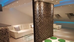 Ein modernes Interieur mit einem weißen Sofa, einem grünen Tisch mit mehreren Sitzplätzen und einer strukturierten Wand.