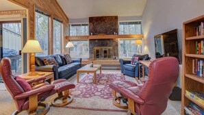 A spacious living room with leather sofas, a fireplace, and a bookshelf. - Near Marina, stables, great location sleeps 8 (Sunriver)
