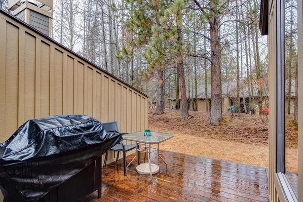 An outdoor patio with a covered grill, a table, and chairs. - Near Marina, stables, great location sleeps 8 (Sunriver)