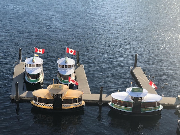 Three boats docked at a pier with Canadian flags.