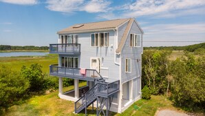 A two-story house with a balcony and a view of a lake. - Cozy Beach House with 270° Spectacular Views (Fairhaven)