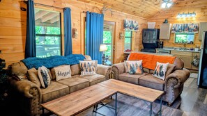 A cozy cabin interior with a sofa set, a wooden table, and a kitchen area. - HAPPY FALL! Fall Special! Beautiful View! Hot Tub,Pet Friendly,9.8🌟










 (Sevierville)