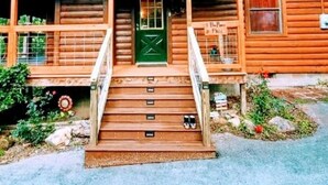 A wooden cabin with a porch, a green door, and a small window. - ROD RUN! Breathtaking View,Hot Tub, Pet Friendly,9.8🌟 Rated










 (Sevierville)