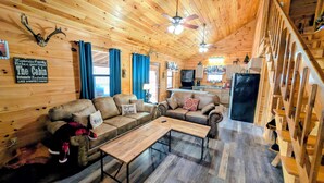 A cozy cabin interior with wooden walls, a sofa set, a dining table, and a kitchen area. - ROD RUN! Breathtaking View,Hot Tub, Pet Friendly,9.8🌟 Rated










 (Sevierville)