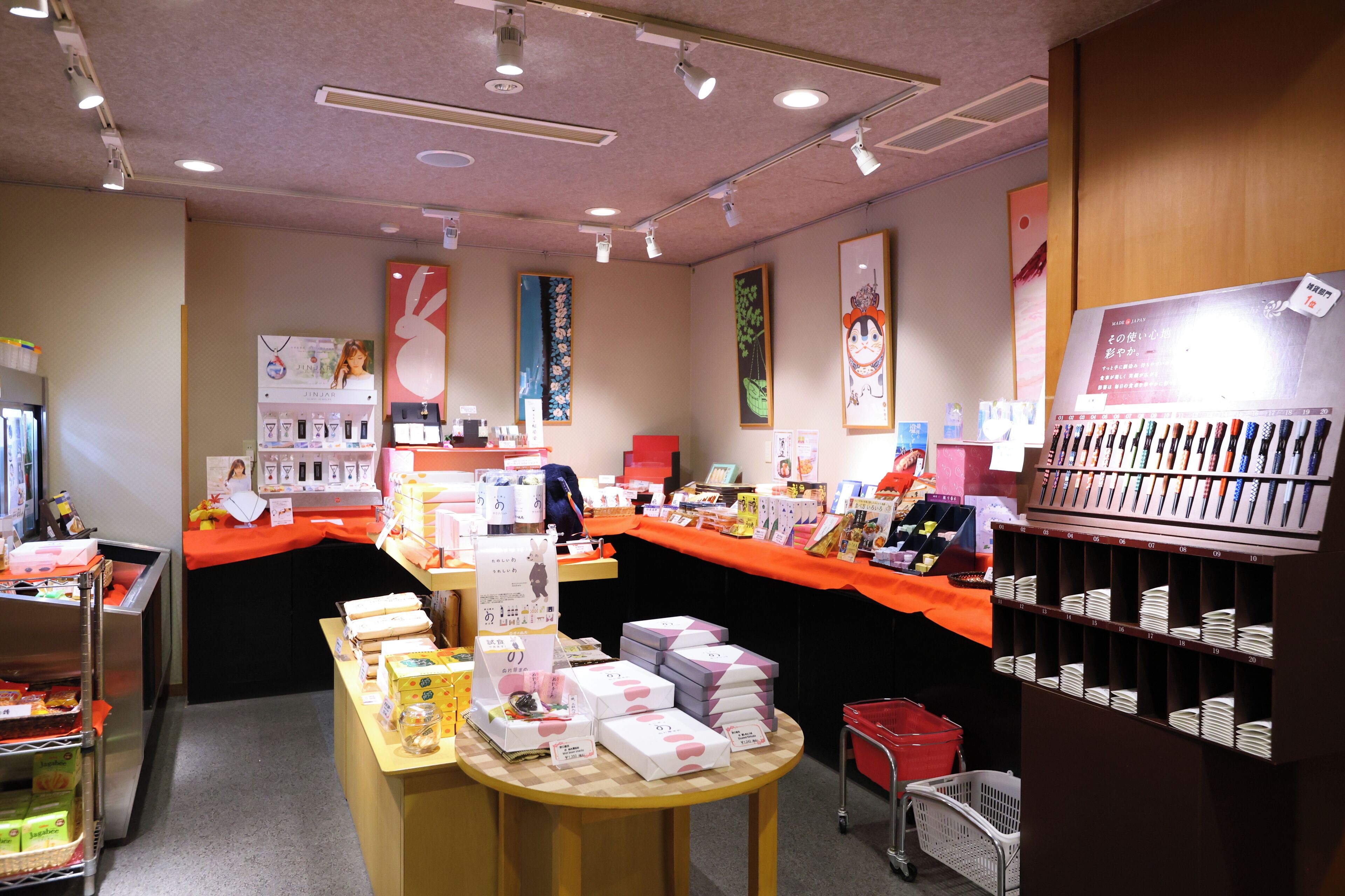A well-lit store with shelves of products, a checkout counter, and a display of boxed items.