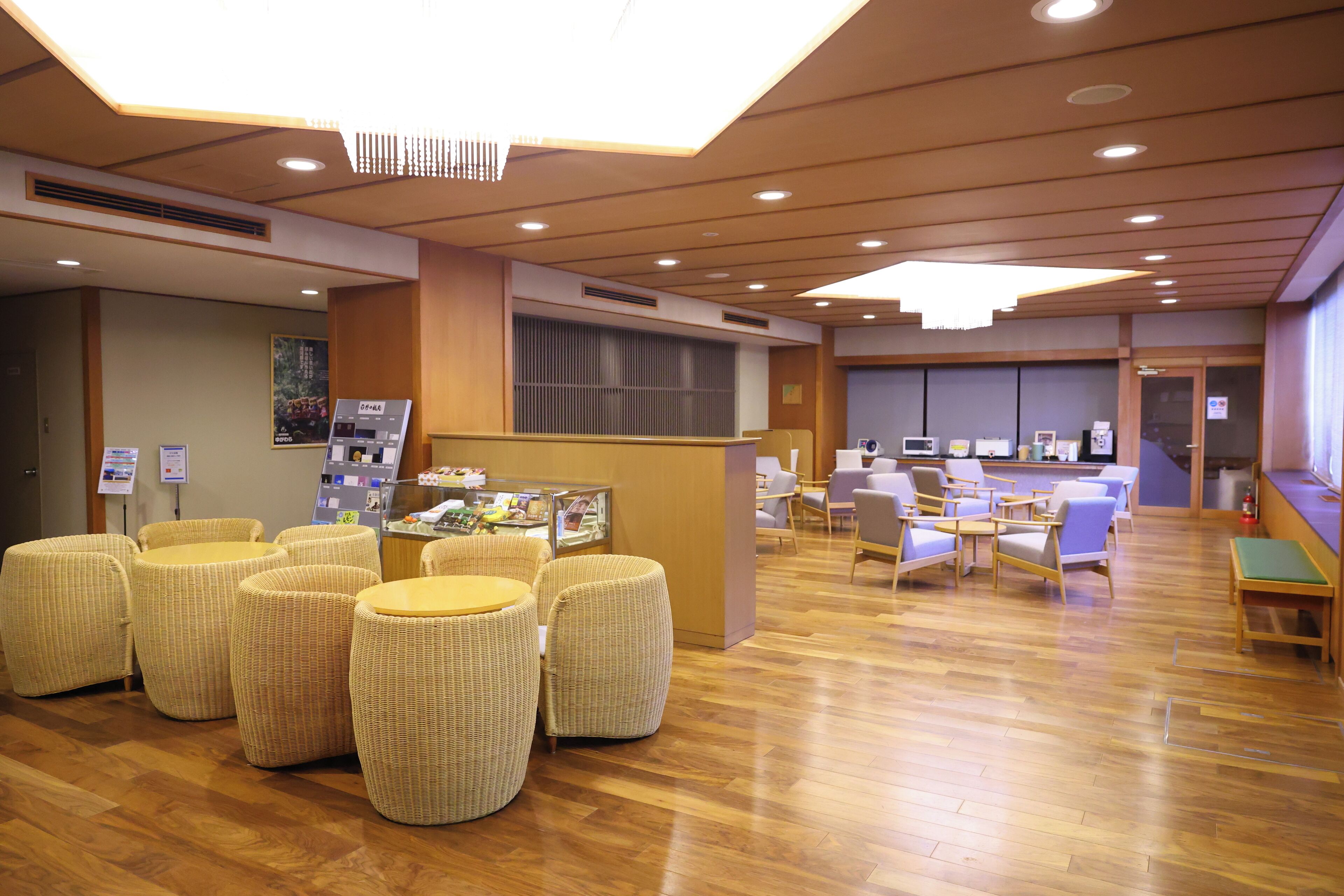 A spacious lobby with a reception desk, comfortable seating areas, and a modern ceiling design.