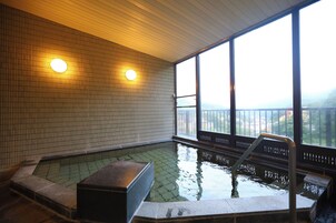 Un jacuzzi con vistas a un puente y montañas.