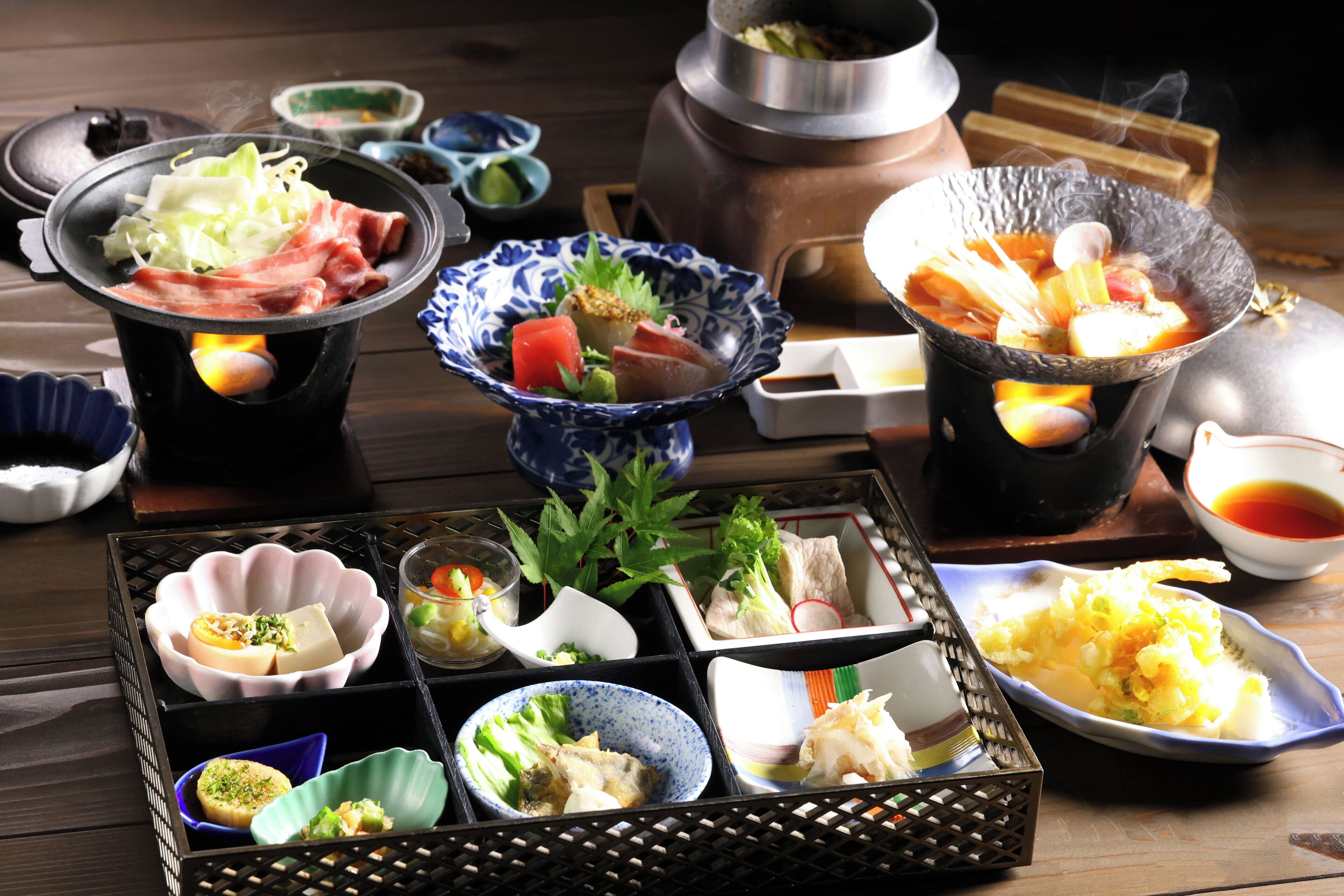 A traditional Japanese hot pot setup with various ingredients and dishes.