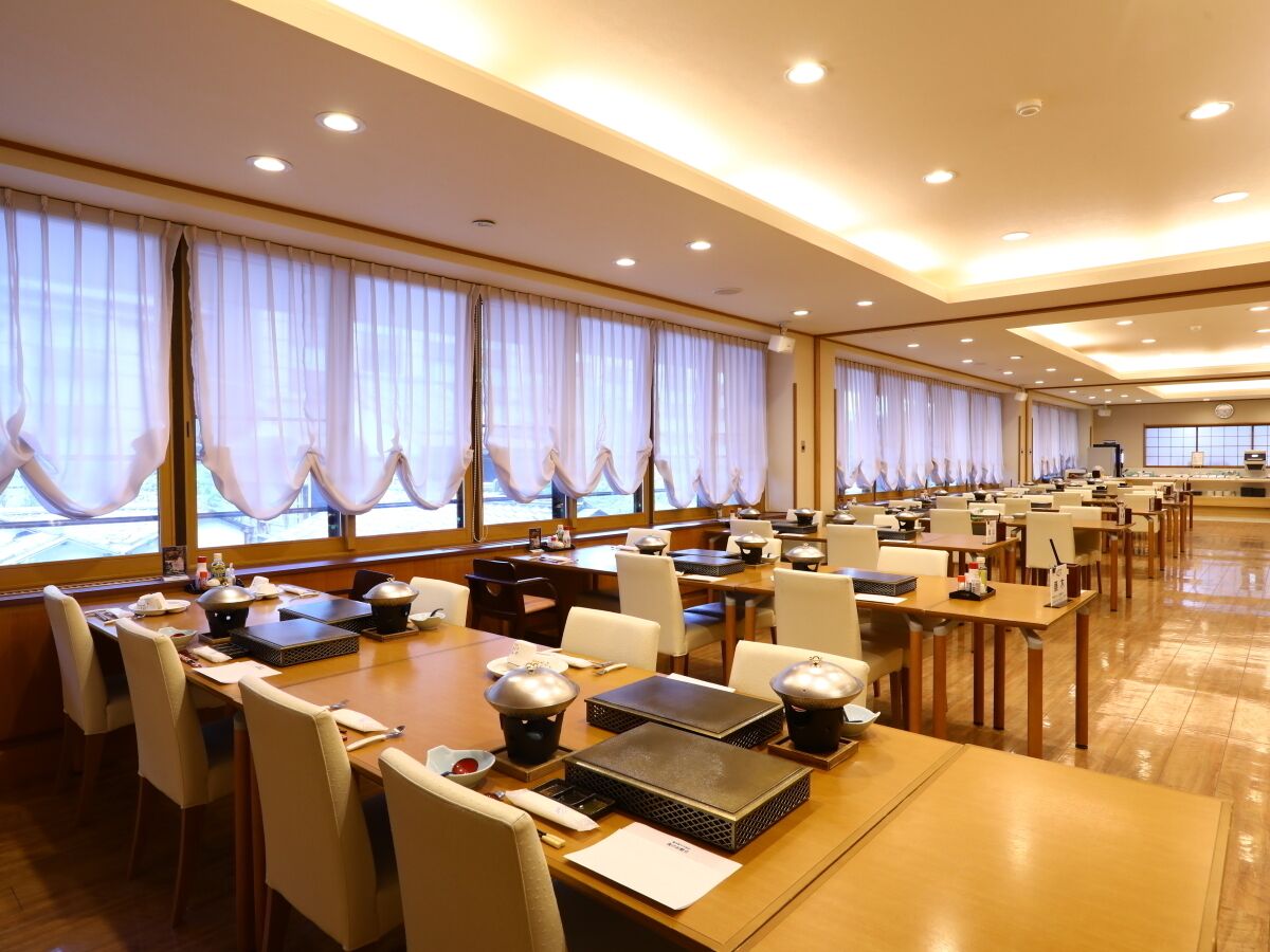 A conference room with multiple tables, chairs, and presentation equipment.