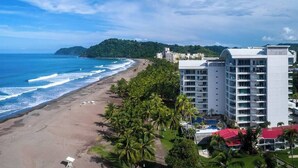 A beachfront hotel with multiple floors, a pool, and a beach view. - Diamante sol 502S Dual Master Steps min walk 2 town (Jaco)