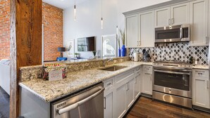 A modern kitchen with granite countertops, stainless steel appliances, and white cabinetry. - 💙 DWNTWN NOLA CHARMER,WITH ALL THE FEELS! 2BR+QUEEN Sleeper Sofa+Private Balcony💙The Steamboat (New Orleans)